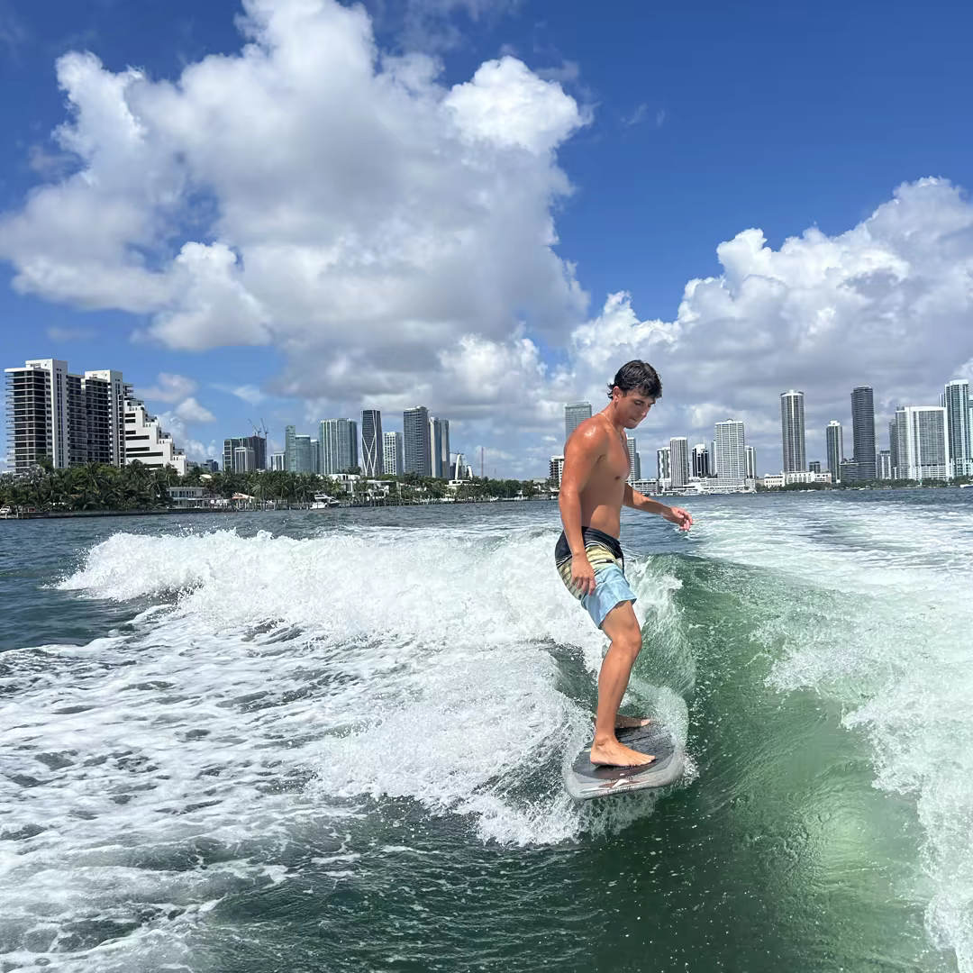 A guest wakesurfing the wave with Miami's skyline behind