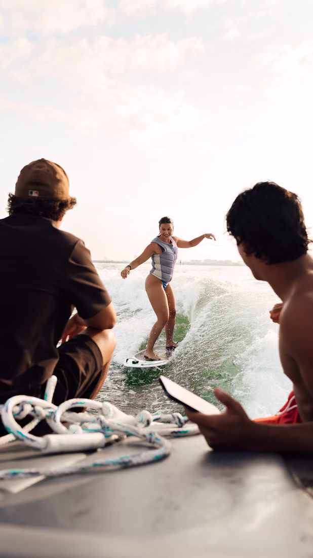 The coach and crew watching a rider surf the wake