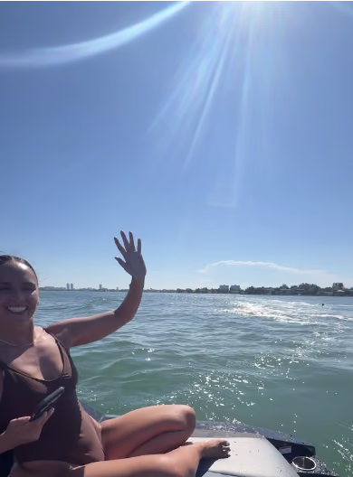 Eric's own photo: a teammate waving from the boat on a sunny Biscayne Bay morning