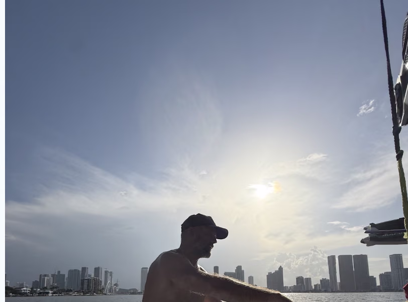 TPG's own photo: golden-hour silhouette on the boat with the Miami skyline behind